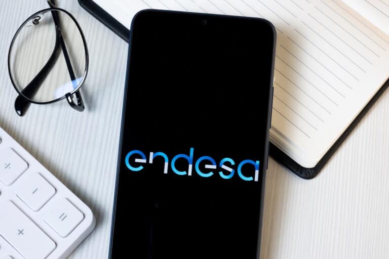 Een smartphone met het Endesa-logo erop. Een bril en een toetsenbord zijn gedeeltelijk zichtbaar.