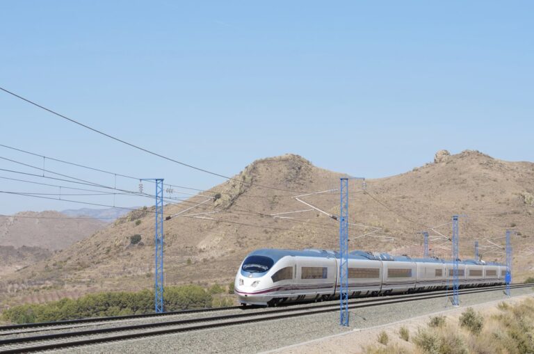Een trein rijdt door een bergachtig landschap in Spanje