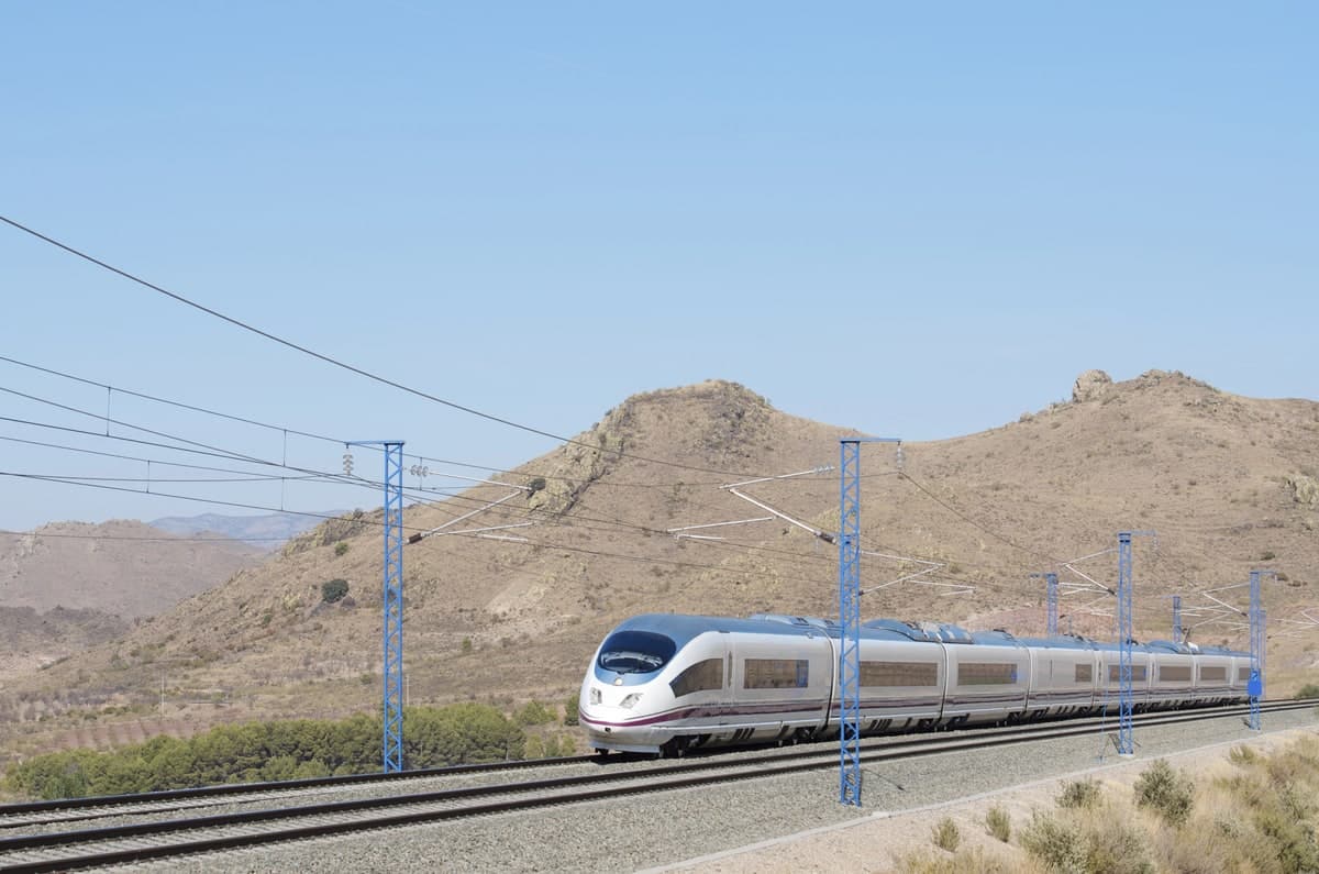 Een trein rijdt door een bergachtig landschap in Spanje