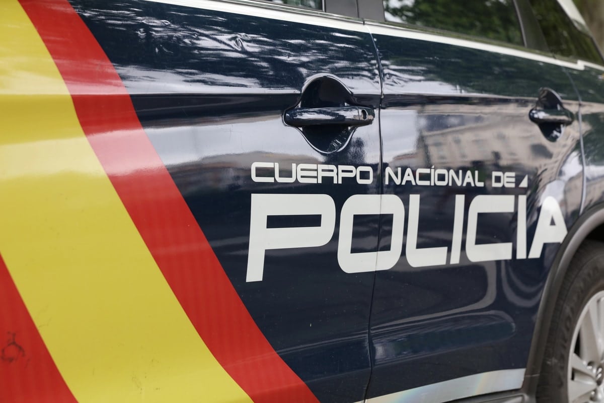 Zijkant van een voertuig van de Spaanse nationale politie met het opschrift “Policía” en de rood-gele strepen van de Spaanse vlag.
