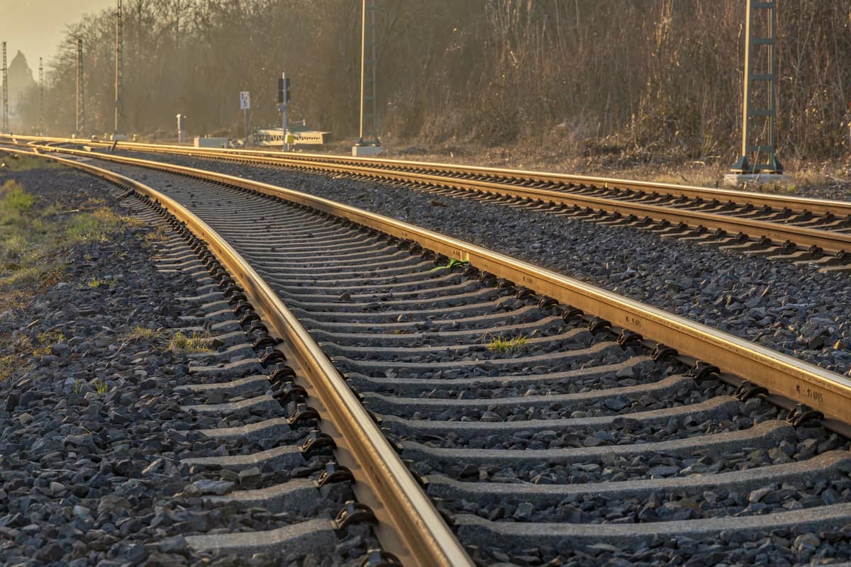 Een spoorweg bij zonopkomst met mistig weer