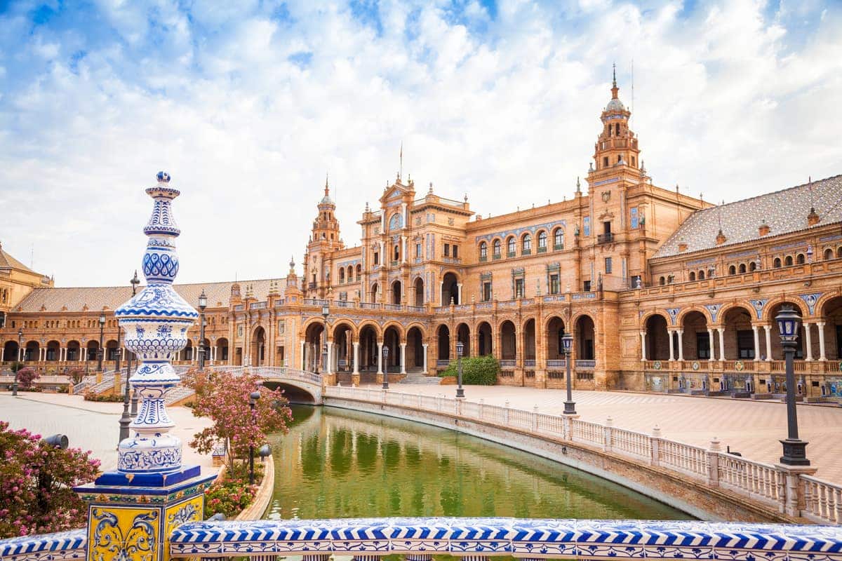 Plaza de España in Sevilla met het monumentale, halfronde gebouwencomplex, brug en waterkanaal op de voorgrond.
