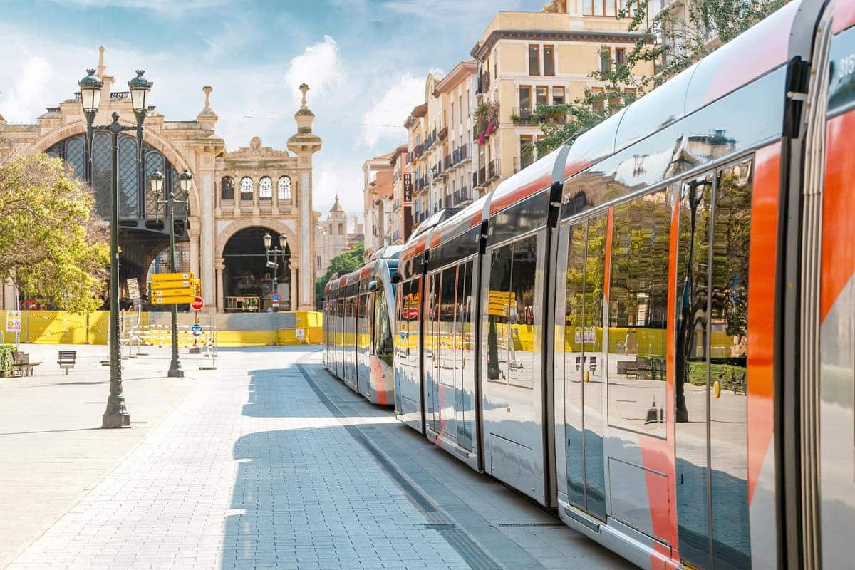 Moderne tram in een Spaanse stad, rijdend langs een plein met historische gebouwen