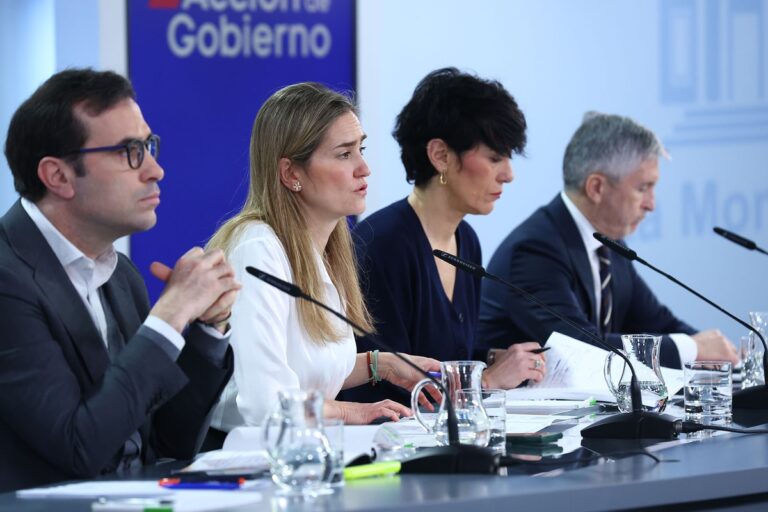 Vier ministers zitten naast elkaar achter microfoons tijdens een persconferentie