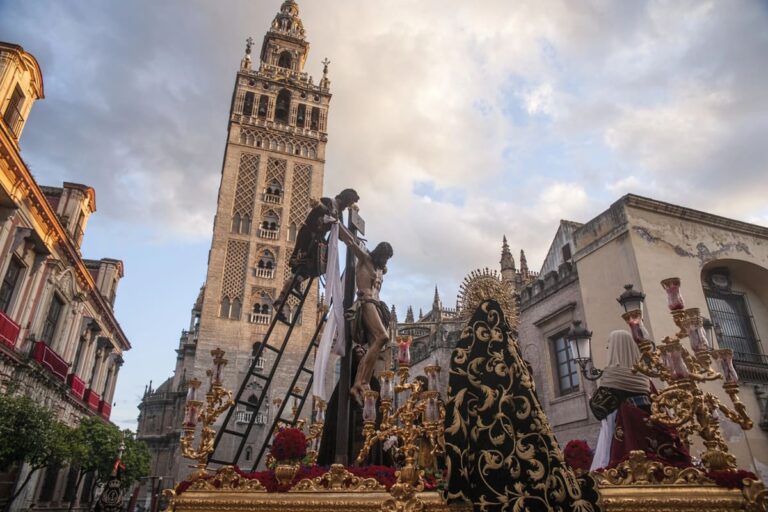 Paso met religieuze beelden tijdens een Semana Santa-processie in Sevilla, met de Giralda op de achtergrond