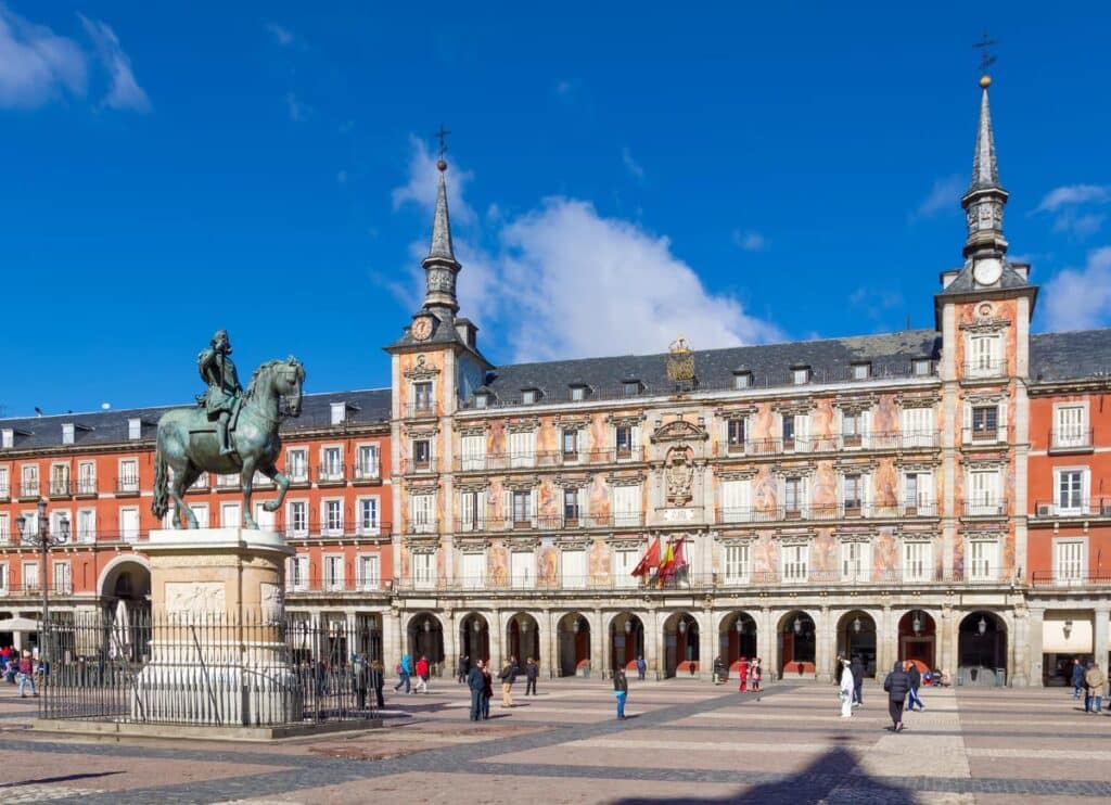 Plaza Mayor in Madrid met standbeeld en gebouwen met arcades.