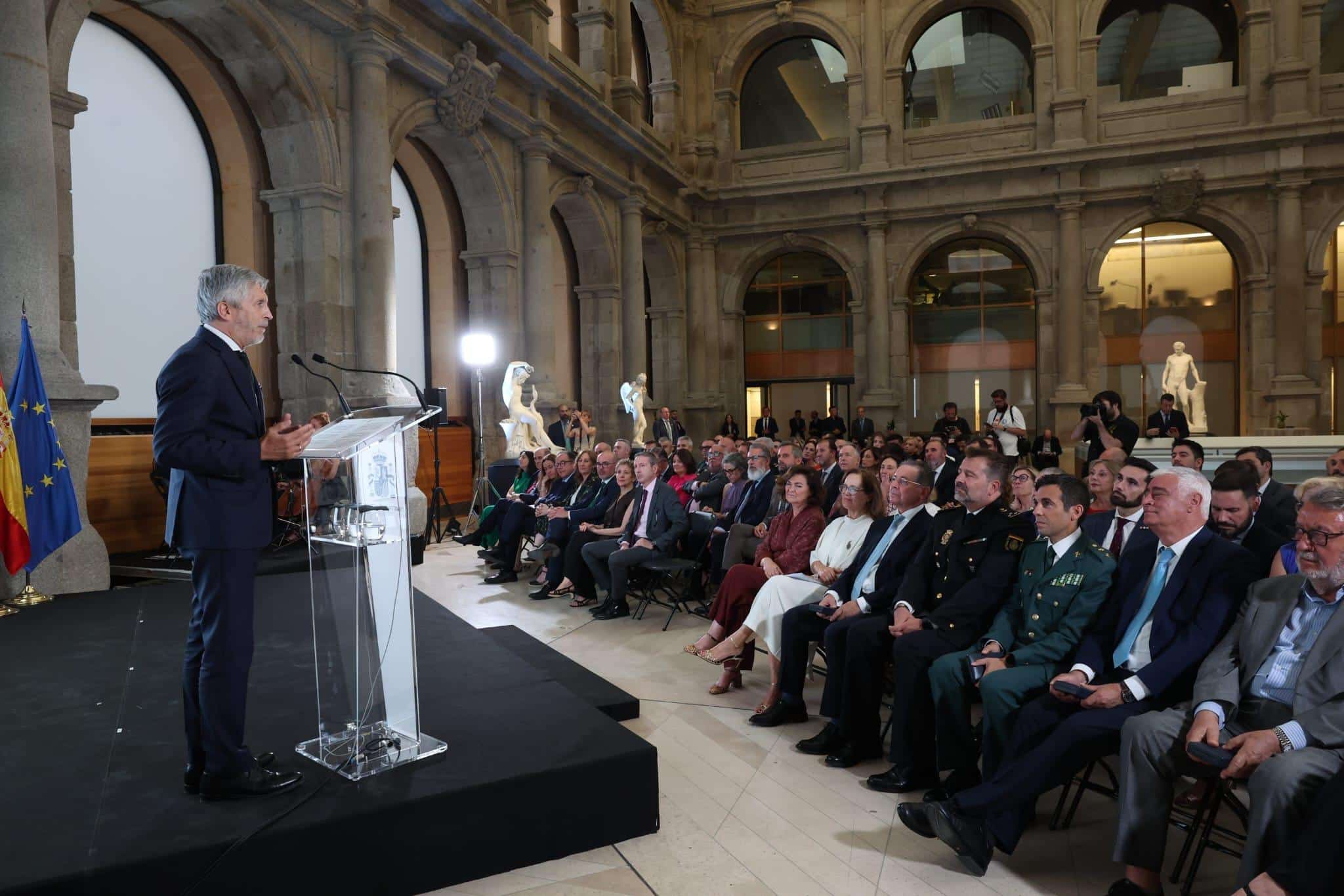 Minister Fernando Grande-Marlaska spreekt tijdens de uitreiking van de Orde van Verdienste voor Veiligheid in het Prado Museum, terwijl genodigden de ceremonie bijwonen.