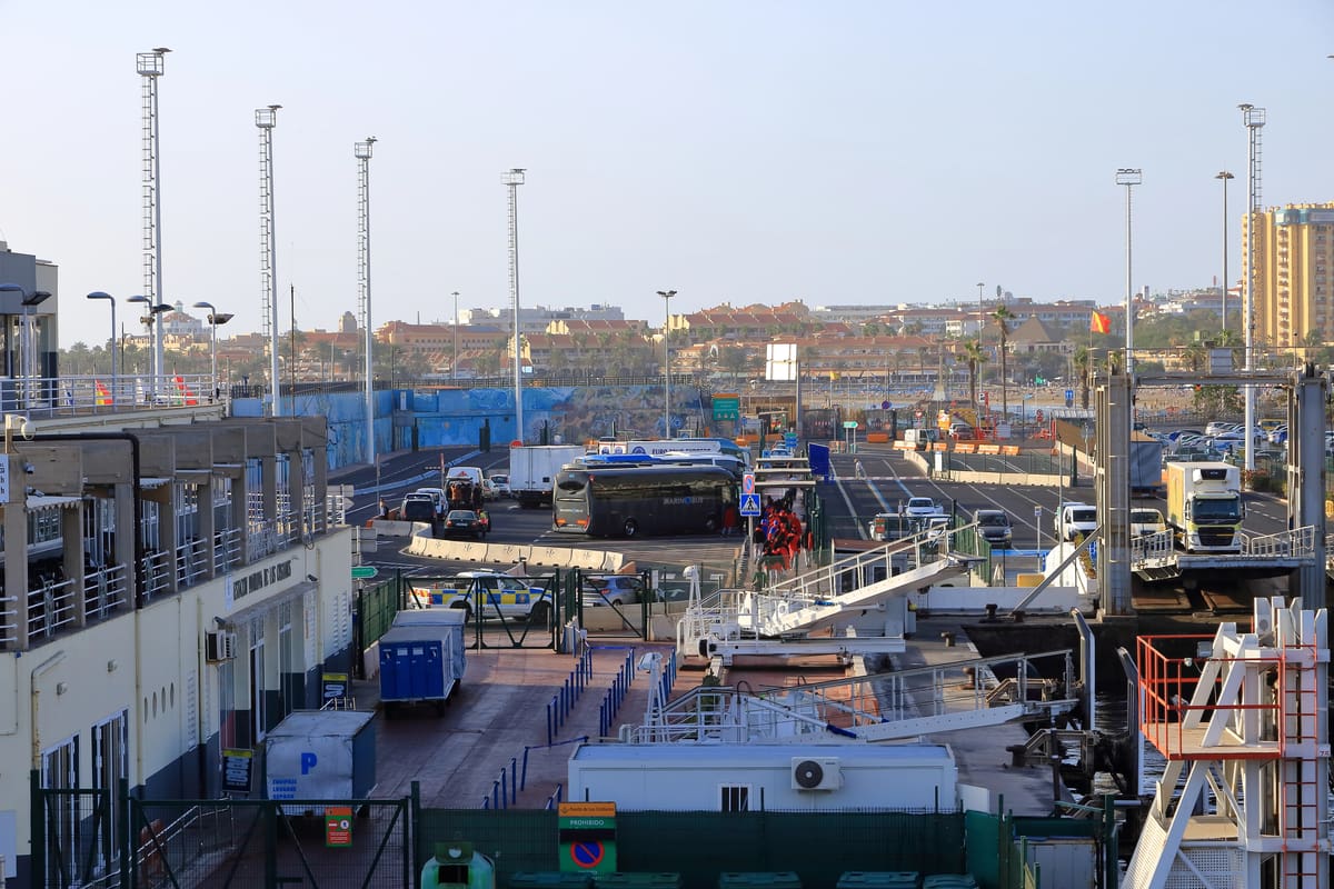 Migranten verzamelen zich bij een ferryterminal in de haven van Los Cristianos op Tenerife.