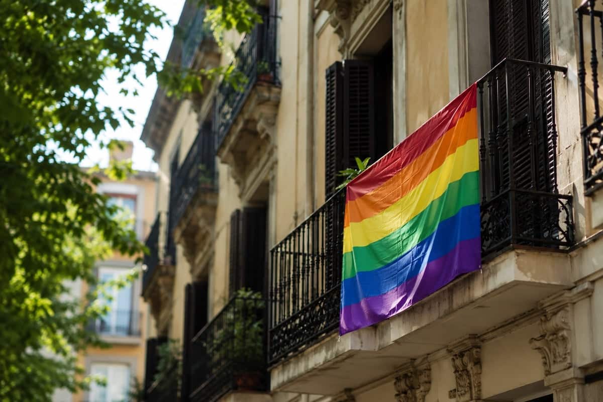 Regenboogvlag hangt aan een balkon van een woongebouw