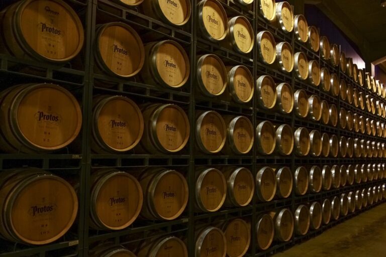 Houten wijnvaten van Bodegas Protos liggen opgestapeld in een wijnkelder.